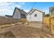 View of a fenced-in backyard featuring a fire pit, garden beds, and a white house at 55 E Regent St, Indianapolis, IN 46225