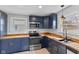 Close up of the kitchen with blue cabinets, stainless steel appliances, and wood countertops at 55 E Regent St, Indianapolis, IN 46225
