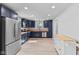 Well-lit kitchen with blue cabinets, stainless steel appliances, and light wood floors at 55 E Regent St, Indianapolis, IN 46225