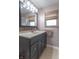 Bathroom with dark vanity, tile, and large mirror at 6149 Winnpeny Ln, Indianapolis, IN 46220
