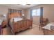 Bedroom with wooden bed frame, ceiling fan and additional chair at 6149 Winnpeny Ln, Indianapolis, IN 46220