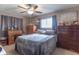 Spacious bedroom with a ceiling fan, large bed, and ample dresser storage at 6149 Winnpeny Ln, Indianapolis, IN 46220