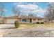 Front view of a ranch house with a brick facade and mature trees at 6149 Winnpeny Ln, Indianapolis, IN 46220