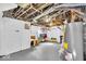 Unfinished basement featuring painted floor and walls, exposed ducts and pipes, a water heater, and storage bins at 625 Sanders St, Indianapolis, IN 46203