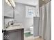 Bright bathroom featuring a double vanity with grey cabinets and stone countertop, and a shower with a white curtain at 625 Sanders St, Indianapolis, IN 46203