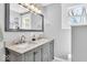 Bright bathroom featuring a double vanity with grey cabinets and stone countertop, and a large framed mirror at 625 Sanders St, Indianapolis, IN 46203