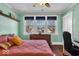 Cozy bedroom featuring a large window, hardwood floors and charming mint green walls at 625 Sanders St, Indianapolis, IN 46203