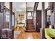 Inviting foyer with hardwood floors, decorative columns, and staircase with rich woodwork at 625 Sanders St, Indianapolis, IN 46203