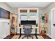 Home office with a standing desk, colorful shelves, and hardwood floors at 625 Sanders St, Indianapolis, IN 46203