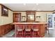 Home bar area featuring wood paneling, seating for three, and a stained glass window at 6437 N Oxbow Way, Indianapolis, IN 46220