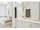 A bathroom with a white vanity, large mirror, soaking tub, and tile flooring at 6437 N Oxbow Way, Indianapolis, IN 46220