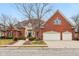 Beautiful brick exterior home with a manicured front lawn, mature trees, and a spacious driveway leading to a garage at 6437 N Oxbow Way, Indianapolis, IN 46220