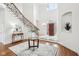 Spacious foyer featuring hardwood floors, an ornate staircase, and a decorative front door at 6437 N Oxbow Way, Indianapolis, IN 46220