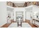 Elegant grand foyer with a view into the dining room, hardwood floors, and an ornate staircase at 6437 N Oxbow Way, Indianapolis, IN 46220