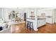 Kitchen island with seating, light hardwood floors, and stainless appliances with open layout to the dining area at 6437 N Oxbow Way, Indianapolis, IN 46220