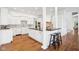 Bright kitchen features a center island, white cabinetry, stainless appliances, and hardwood floors at 6437 N Oxbow Way, Indianapolis, IN 46220