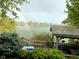 Picturesque lake view with a vibrant rainbow, lush greenery, and an attractive covered patio at 6437 N Oxbow Way, Indianapolis, IN 46220