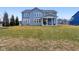 Spacious backyard showcases the home's exterior, covered patio, and lush green lawn at 6777 Pulaski Ct, Carmel, IN 46033