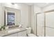 Bright bathroom featuring a single sink vanity, a framed mirror, and a glass-enclosed shower at 6777 Pulaski Ct, Carmel, IN 46033
