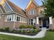 Beautiful two-story brick home featuring a landscaped yard with purple flowers and blue planters by front door at 6777 Pulaski Ct, Carmel, IN 46033
