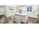 Bright kitchen features stainless steel appliances, white cabinets, large island, and modern countertops at 6777 Pulaski Ct, Carmel, IN 46033
