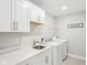 Bright laundry room with white cabinets, sink and modern washer and dryer at 6777 Pulaski Ct, Carmel, IN 46033