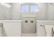 Modern shower with dual fixtures, neutral tile, and built-in shelving for added convenience at 6777 Pulaski Ct, Carmel, IN 46033