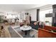 Open concept living room with dark gray sectional sofa and colorful accents at 9891 Sunbranch Dr, Carmel, IN 46290