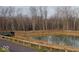 Community pond with walking path and wooded backdrop at 9891 Sunbranch Dr, Carmel, IN 46290