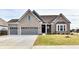 Two-story home with gray brick and a three-car garage at 11722 Platt St, Noblesville, IN 46060