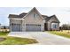 Two-story house with gray brick exterior, three-car garage, and manicured lawn at 11722 Platt St, Noblesville, IN 46060