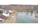 Aerial view of homes surrounding a scenic pond with mature trees during winter at 1229 Tealpoint Cir, Indianapolis, IN 46229