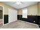 Bedroom featuring yellow upper walls, black lower walls, closet, and a window at 1229 Tealpoint Cir, Indianapolis, IN 46229