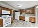Bright kitchen features white appliances, wood cabinets, and a neutral tile floor at 1229 Tealpoint Cir, Indianapolis, IN 46229