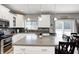 Well-lit kitchen with white cabinets, a center island, and an adjacent dining area with a sliding glass door at 1295 Longleaf St, Avon, IN 46123