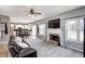 Cozy living room with a fireplace, television, and plush carpet, flowing into the kitchen and dining area at 1295 Longleaf St, Avon, IN 46123