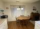 Cozy dining area with a round wooden table, four chairs, and a window with lace curtains at 1348 Mccormicks Cir, Danville, IN 46122