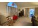 Cozy living room featuring a rocking chair, large window with curtains, and sliding door to backyard at 1348 Mccormicks Cir, Danville, IN 46122