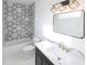 Modern bathroom with white hexagon tile, gold fixtures, and dark vanity at 1523 Marlowe Ave, Indianapolis, IN 46201