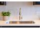 Modern kitchen sink with gold faucet and white herringbone tile backsplash at 1523 Marlowe Ave, Indianapolis, IN 46201