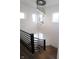 Modern staircase with dark wood and metal railings, complemented by a stunning chandelier at 1523 Marlowe Ave, Indianapolis, IN 46201