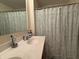 Bright bathroom featuring a double sink and a shower/tub with a leaf-patterned curtain at 15314 Mystic Rock Dr, Carmel, IN 46033