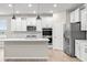 Modern kitchen with white cabinets, stainless steel appliances, and a large island at 16930 Cole Evans Dr, Noblesville, IN 46060