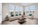 Sunroom with beige couch, two armchairs, and large windows at 16930 Cole Evans Dr, Noblesville, IN 46060