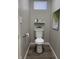 Modern half-bathroom features gray walls, a floating shelf, and a stylish toilet at 2426 S Holt S Rd, Indianapolis, IN 46241