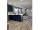 Open kitchen with navy cabinets, quartz countertop island, and a view into the dining area at 2426 S Holt S Rd, Indianapolis, IN 46241