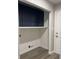 Bright laundry room with blue cabinets, white shelf and gray wood floor at 2426 S Holt S Rd, Indianapolis, IN 46241