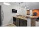 Basement wet bar featuring a countertop with sink, custom cabinets and convenient bar seating at 377 Morningside Dr, Brownsburg, IN 46112