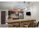 Basement wet bar with stone accents, bar seating, refrigerator and cabinetry at 377 Morningside Dr, Brownsburg, IN 46112