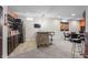 Entertaining basement bar area with stone accents, bar seating, refrigerator and adjacent game room at 377 Morningside Dr, Brownsburg, IN 46112